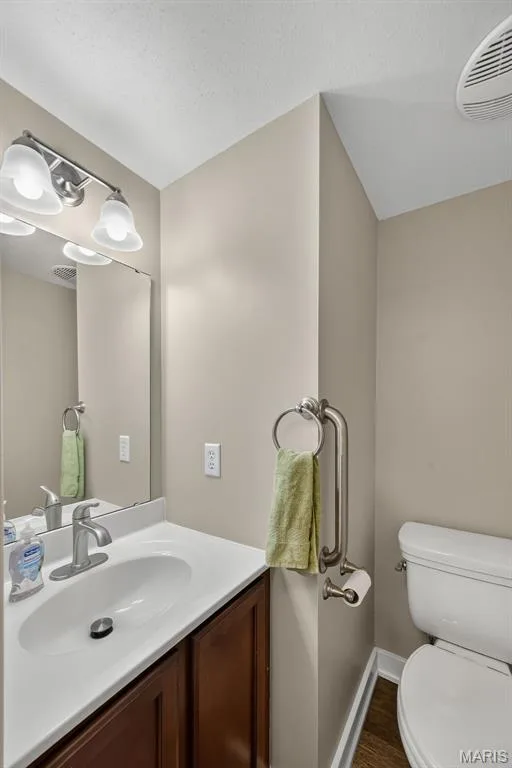 Well-appointed bathroom featuring a white dual-sink vanity with wood-finish cabinetry, chrome faucet fixtures, and ample countertop space — 3471 Hiram Street, St Charles, MO 63301