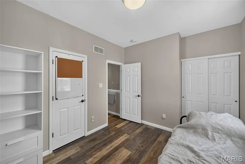 Spacious bedroom featuring wood-finish flooring, soft neutral wall tones, and abundant natural light — 3471 Hiram Street, St Charles, MO 63301