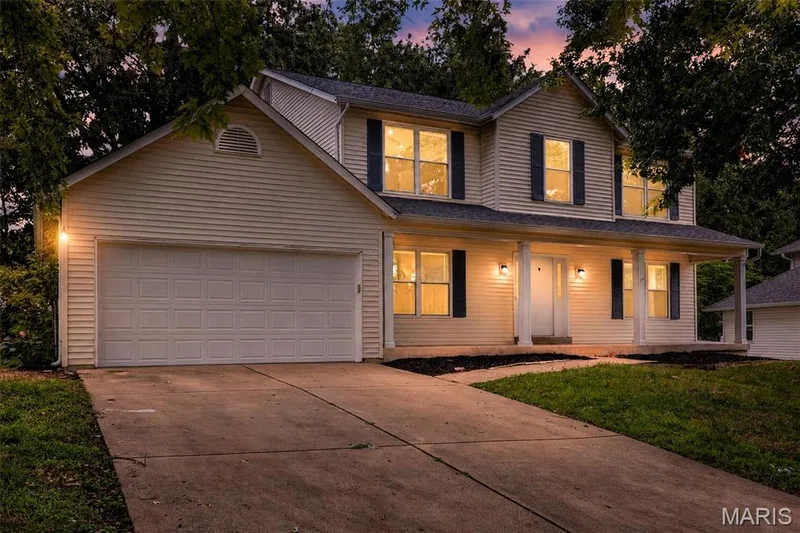 Two-story residence featuring light-toned horizontal siding and dark contrasting shutters — 2947 Bromley Drive, O'Fallon, MO 63368