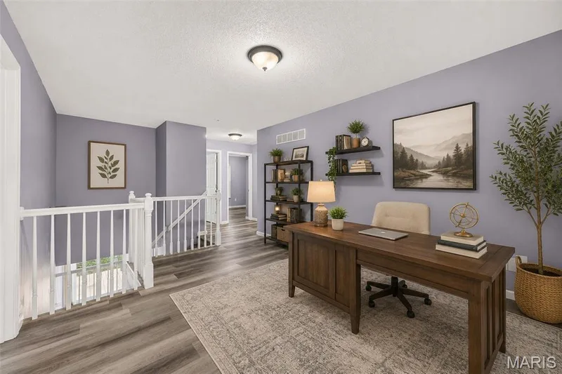 Open loft area featuring wood-finish flooring, white banister, and recessed ceiling lighting — 2947 Bromley Drive, O'Fallon, MO 63368