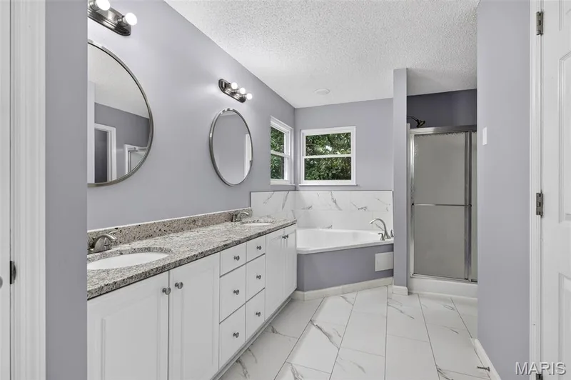 Double vanity with white cabinetry, granite-finish countertop, and undermount sinks — 2947 Bromley Drive, O'Fallon, MO 63368