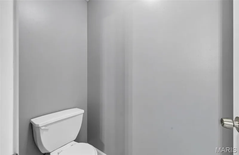 White toilet fixture within a gray-painted lavatory — 2947 Bromley Drive, O'Fallon, MO 63368
