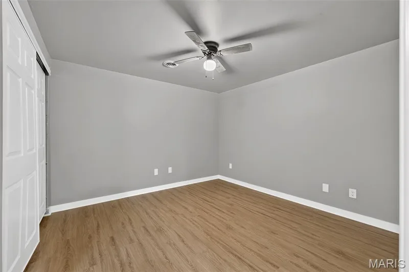 Room featuring wood-finish flooring, light grey painted walls, and white baseboards — 2947 Bromley Drive, O'Fallon, MO 63368