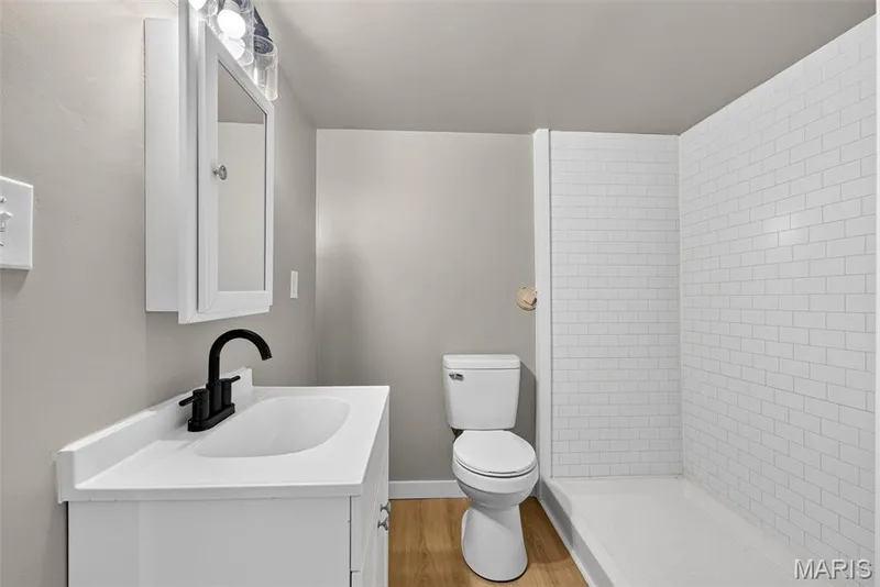 Bathroom featuring a white vanity with integrated sink, matte black faucet, and white countertop — 2947 Bromley Drive, O'Fallon, MO 63368