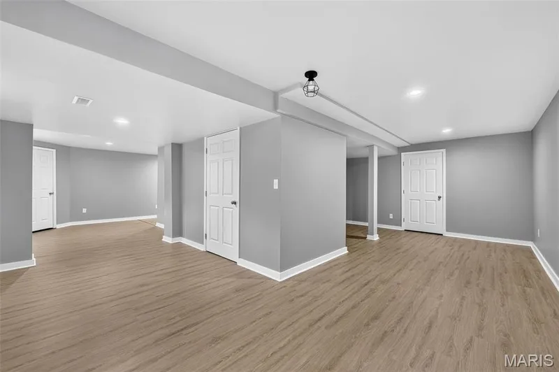 Spacious lower level featuring light wood-finish flooring, recessed lighting, white baseboards, and paneled interior doors — 2947 Bromley Drive, O'Fallon, MO 63368