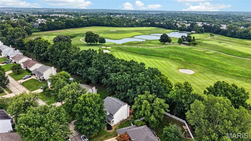 Aerial perspective showcasing a residential community bordering a golf course with multiple greens, sand traps, and water features — 2947 Bromley Drive, O'Fallon, MO 63368