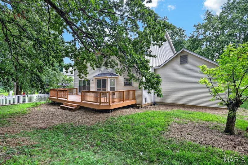 Expansive rear yard featuring a multi-level wood deck with perimeter railing — 2947 Bromley Drive, O'Fallon, MO 63368
