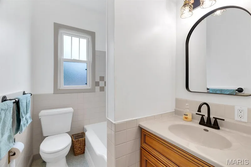 Updated main floor bathroom with checkerboard shower tile & ceramic penny tile flooring — 915 N Kingshighway Street, St Charles, MO 63301