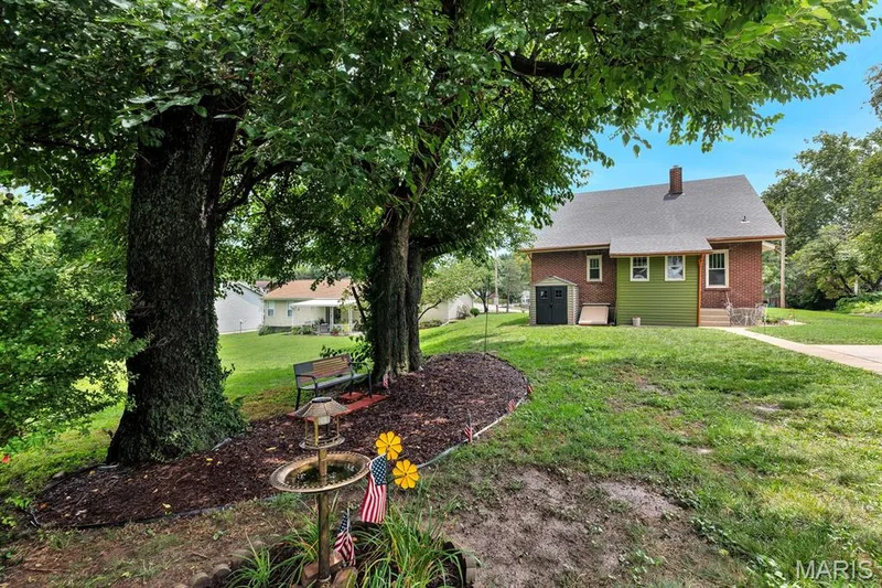 Mature trees & bushes, new mulch bed with sitting area and landscaping — 915 N Kingshighway Street, St Charles, MO 63301