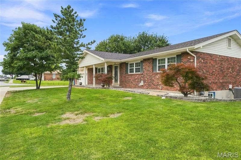 Traditional brick ranch-style residence featuring a covered front porch, white siding gables. — 1613 Tamarack Drive, St Charles, MO 63301