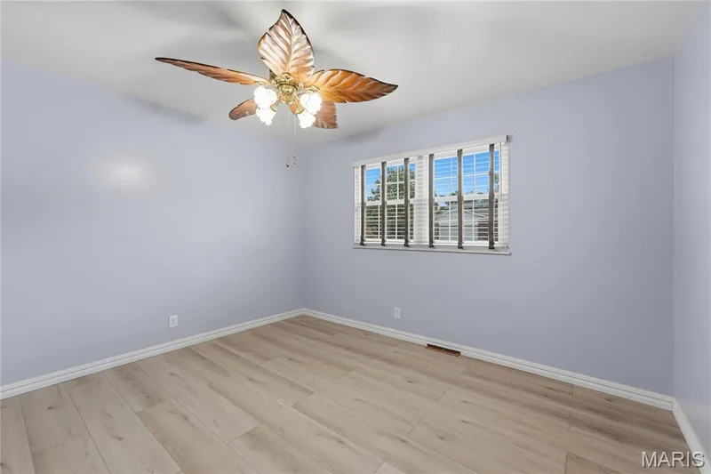 Spacious room featuring wood-finish flooring, and white trim — 1613 Tamarack Drive, St Charles, MO 63301