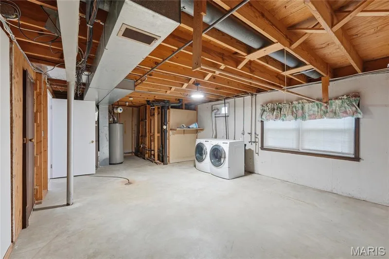 Concrete floor basement space featuring exposed wood joists and a visible furnace duct system — 1613 Tamarack Drive, St Charles, MO 63301