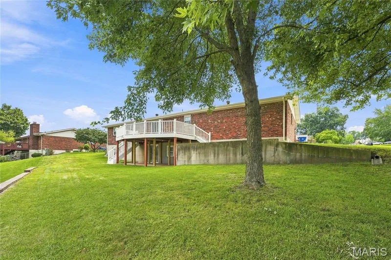 Expansive green lawn with a mature tree providing natural shade — 1613 Tamarack Drive, St Charles, MO 63301