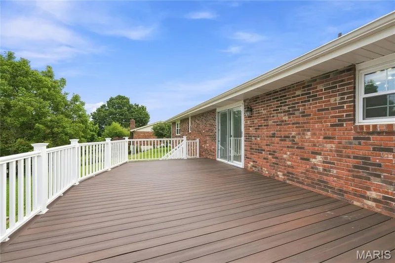 Spacious outdoor deck featuring composite decking and white railings — 1613 Tamarack Drive, St Charles, MO 63301