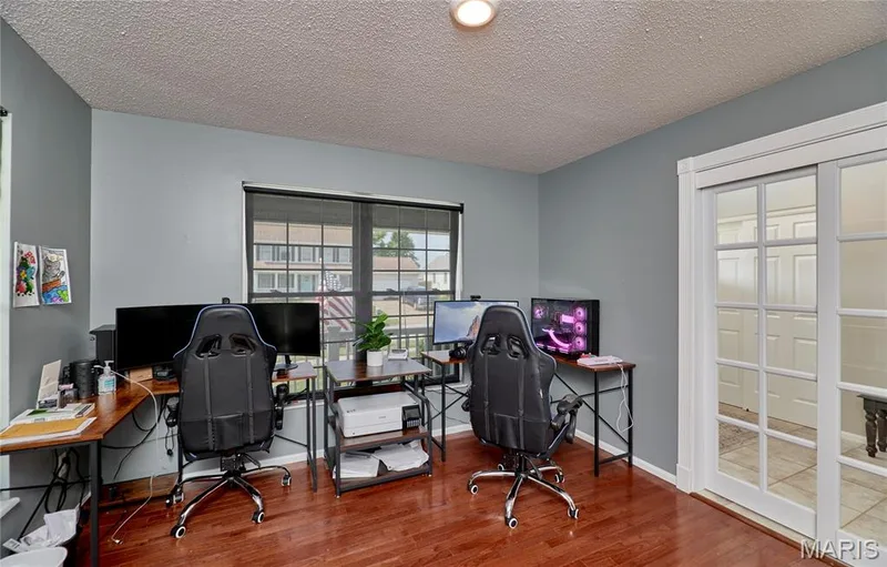 Office space featuring wood-finish flooring, a large window, and double French doors — 3 Floral Court, O'Fallon, MO 63368