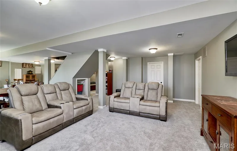Expansive carpeted area featuring recessed lighting, a neutral color palette, white trim, and a partially visible staircase — 3 Floral Court, O'Fallon, MO 63368