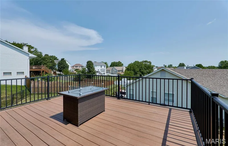 Expansive outdoor deck featuring wood-finish composite decking and black metal railings — 3 Floral Court, O'Fallon, MO 63368