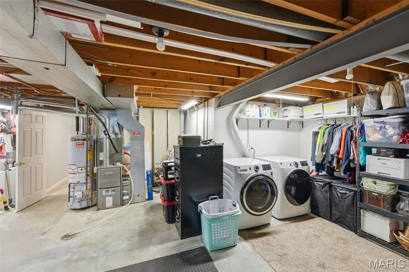 Storage room in basement has laundry hookups, built in shelving and space for a workshop. — 17 Oak Hill Lane, St Peters, MO 63376