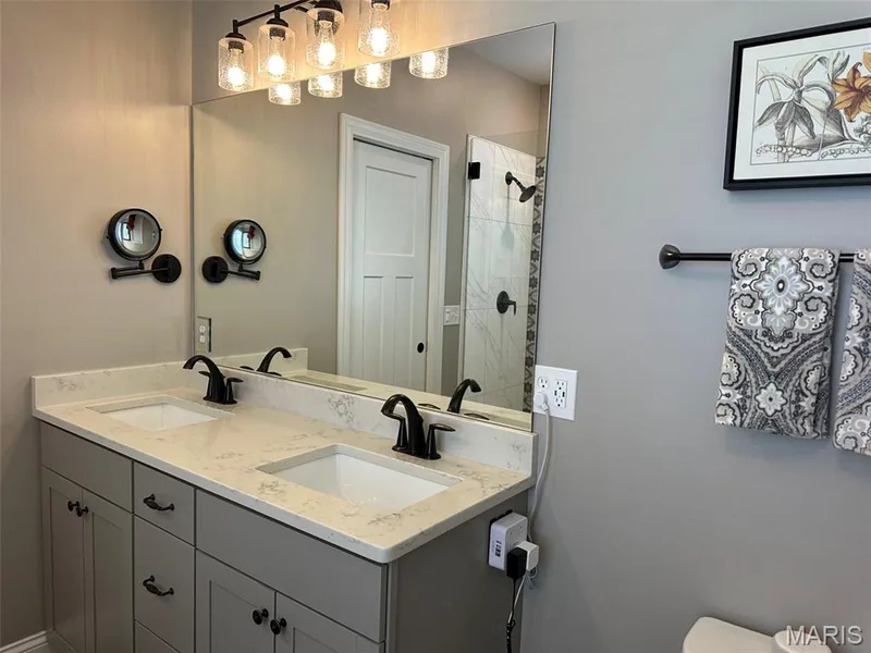 Double vanity with light-toned countertop, dual sinks, and matte black fixtures — 110 Alta Mira Court, Dardenne Prairie, MO 63368