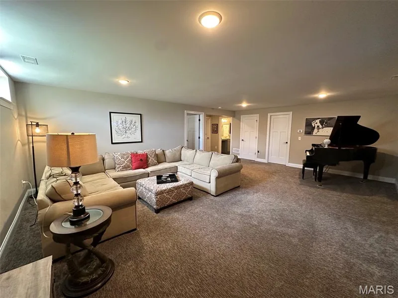 Spacious living area featuring neutral-toned walls, recessed lighting, and soft carpet flooring — 110 Alta Mira Court, Dardenne Prairie, MO 63368