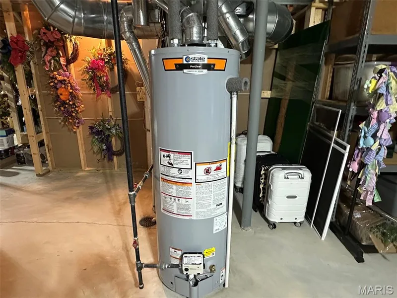 Utility room featuring a high-efficiency gas water heater with orange accents and multiple connection ports, concrete flooring, and metal piping infrastructure — 110 Alta Mira Court, Dardenne Prairie, MO 63368