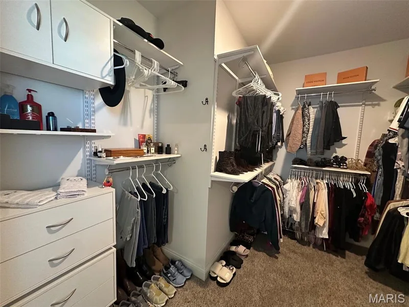 Custom closet system featuring white shelving, hanging rods, and built-in drawers — 110 Alta Mira Court, Dardenne Prairie, MO 63368