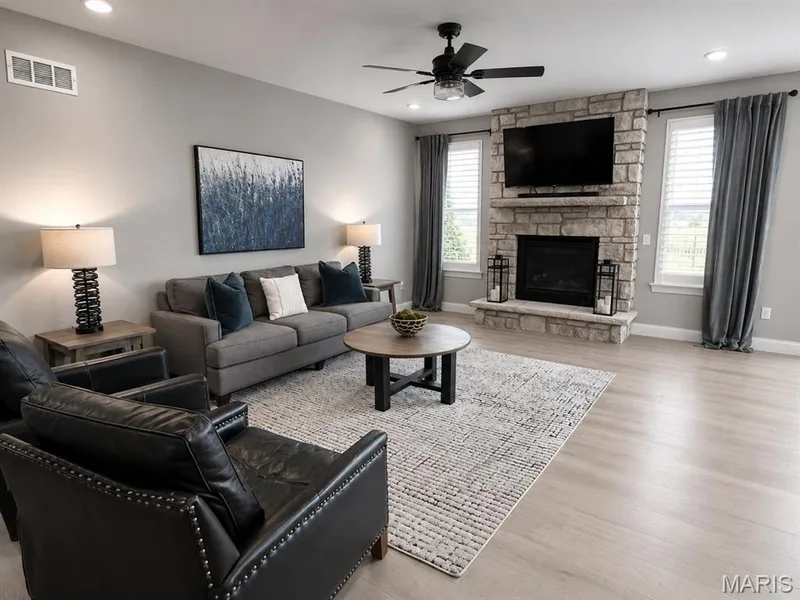 Living area featuring a stone fireplace, light wood-finish flooring, recessed lighting, and a ceiling fan — 110 Alta Mira Court, Dardenne Prairie, MO 63368