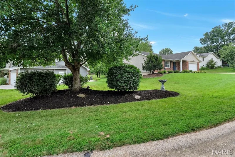 Abundant and sprawling side yard with decorative landscaping berm. — 104 Cedar Crest Court, St Charles, MO 63304
