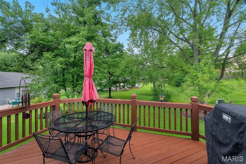 Expansive wood-finish deck with perimeter railing and open-air setting — 104 Cedar Crest Court, St Charles, MO 63304