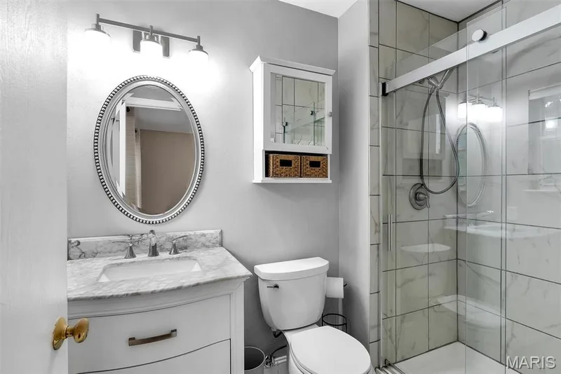 White vanity with a stone countertop and undermount sink — 104 Cedar Crest Court, St Charles, MO 63304