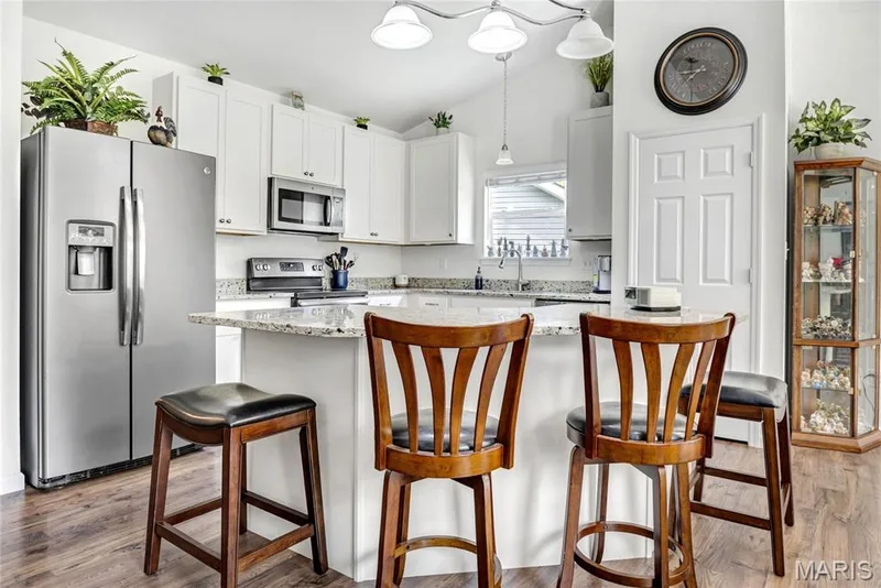 Another view of the kitchen with 42" upgraded white cabinetry, granite countertops, built-in microwave, electric smooth-top stove — 492 Pleasant Breeze Drive, Wentzville, MO 63385