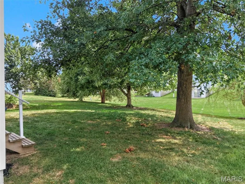 Expansive green lawn with mature trees and a stepped entry — 669 Homerun Drive, O'Fallon, MO 63366