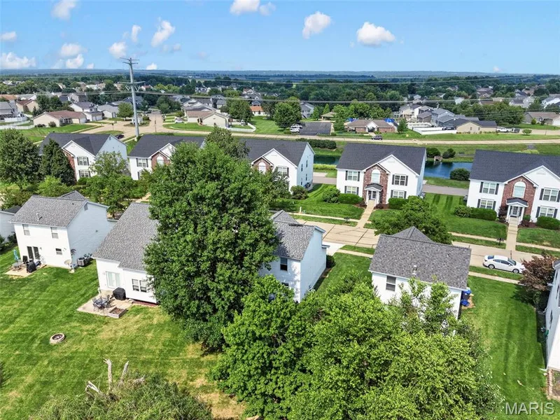 Residential neighborhood setting featuring multiple two-story homes with shingle roofs and established landscaping — 669 Homerun Drive, O'Fallon, MO 63366