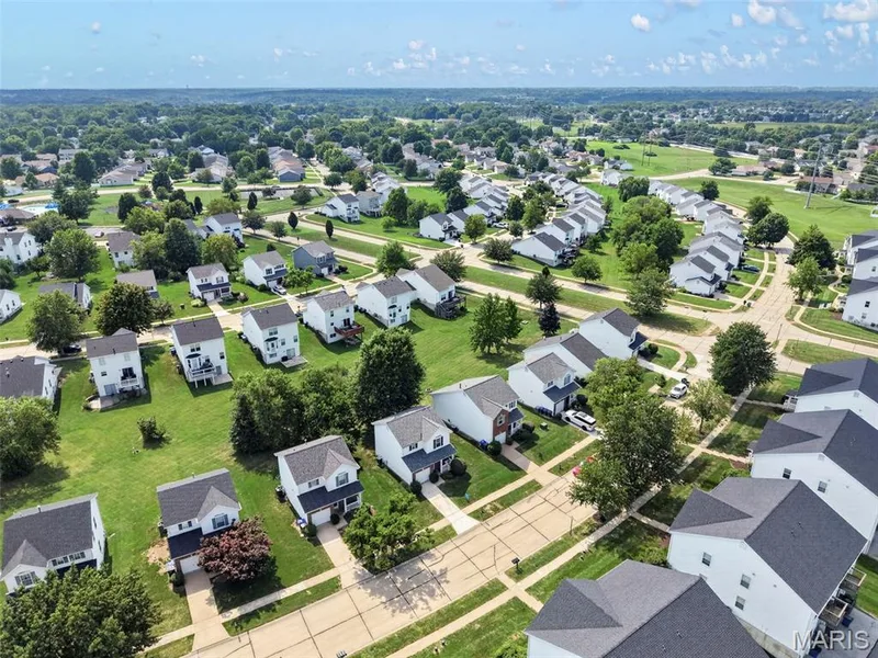 Residential neighborhood featuring detached homes with grey shingle roofs and white siding — 669 Homerun Drive, O'Fallon, MO 63366