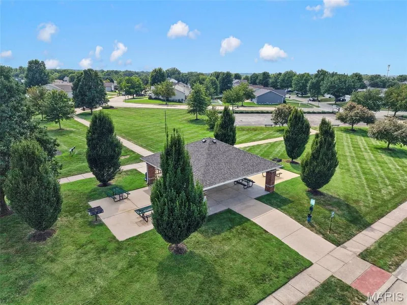 Community green space featuring a pavilion with a gabled roof, brick columns, and concrete walkways — 669 Homerun Drive, O'Fallon, MO 63366
