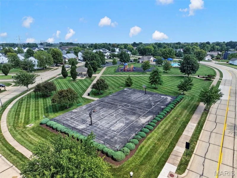 Recreational basketball court, adjacent park space, community playground, shaded picnic pavilion, and a residential street with sidewalks — 669 Homerun Drive, O'Fallon, MO 63366