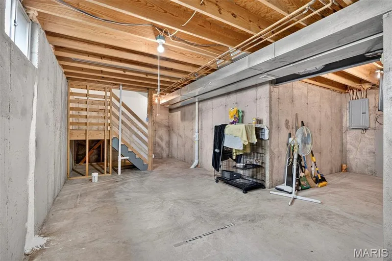 Spacious basement featuring exposed wood-beam ceiling, polished concrete flooring, and abundant natural light from high windows — 669 Homerun Drive, O'Fallon, MO 63366