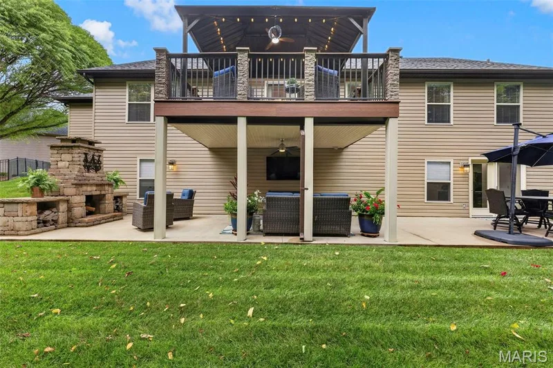 Plenty of outdoor entertainment space with stone fireplace, large patio, and amazing composite deck with pergola and stone columns. — 132 Miranda Court, Wentzville, MO 63385