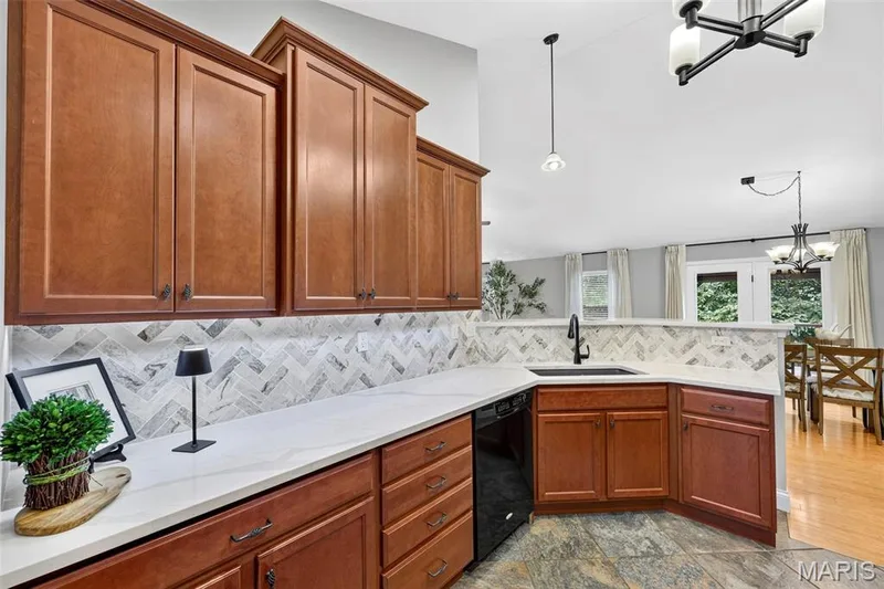The kitchen has granite counter tops, beautiful backsplash, walk in pantry, staggered custom cabinets and under cabinet lighting. — 132 Miranda Court, Wentzville, MO 63385