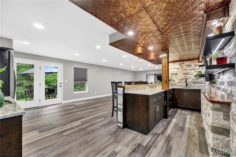 WOW!! This is an amazing hang out !! Wet bar, custom wood countertop, refrigerator, stone accents, luxury vinyl flooring, full bath, media/could be 4th bedroom with the addition of a barn door!! — 132 Miranda Court, Wentzville, MO 63385
