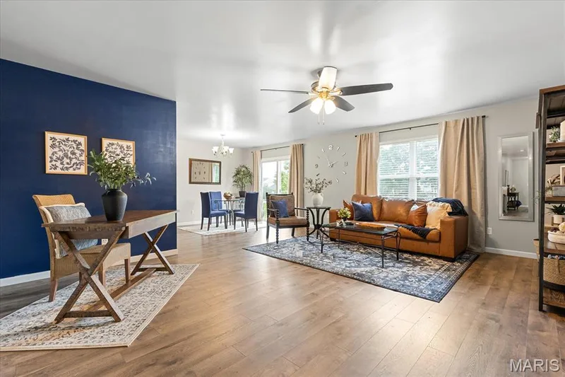 Experience immediate warmth in the open living room designed for gathering, working, and unwinding. Tons of natural light flood this space with large windows. — 146 Tuscany Lane, Wentzville, MO 63385