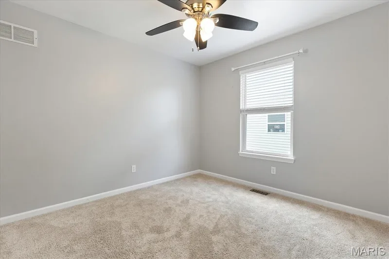 Welcome family or guests into the sunlit additional bedroom that offers simple comfort and modern ceiling fan breeze. — 146 Tuscany Lane, Wentzville, MO 63385