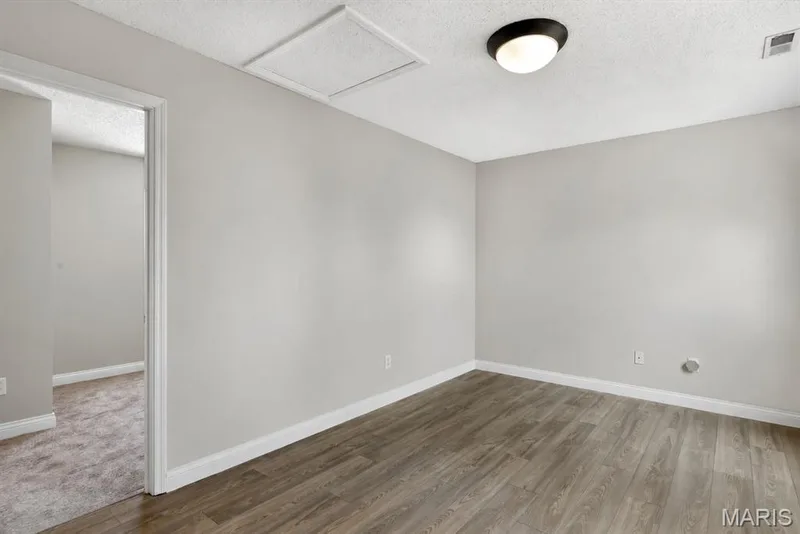 Wood-finish flooring, neutral wall tones, and overhead lighting — 14 Bridgeton Court, Wentzville, MO 63385