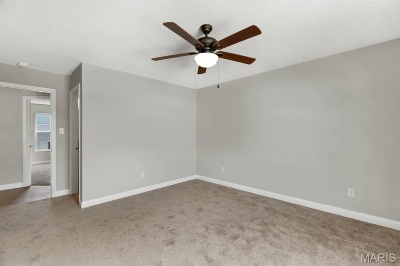 Neutral paint scheme with carpeting and a ceiling fan — 14 Bridgeton Court, Wentzville, MO 63385