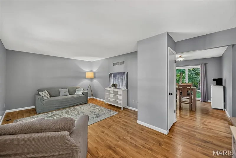 Living area featuring laminate wood-finish flooring and light gray painted walls — 23 Crescent Woods Drive, St Peters, MO 63376