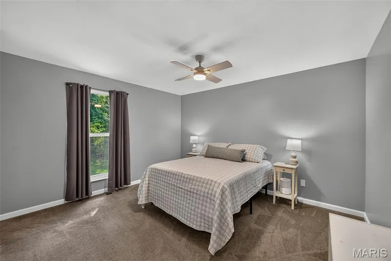 Spacious primary bedroom showcasing neutral gray walls, plush carpeting, and abundant natural light — 23 Crescent Woods Drive, St Peters, MO 63376
