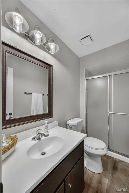 Modern bathroom featuring a white ceramic sink with dark vanity cabinetry — 23 Crescent Woods Drive, St Peters, MO 63376