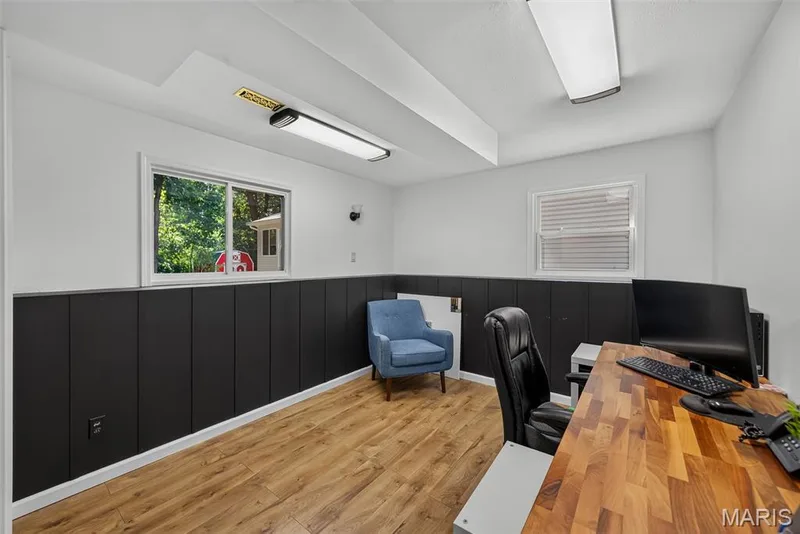 Modern home office featuring crisp white walls, recessed lighting, and a striking two-tone design with black wainscoting — 23 Crescent Woods Drive, St Peters, MO 63376