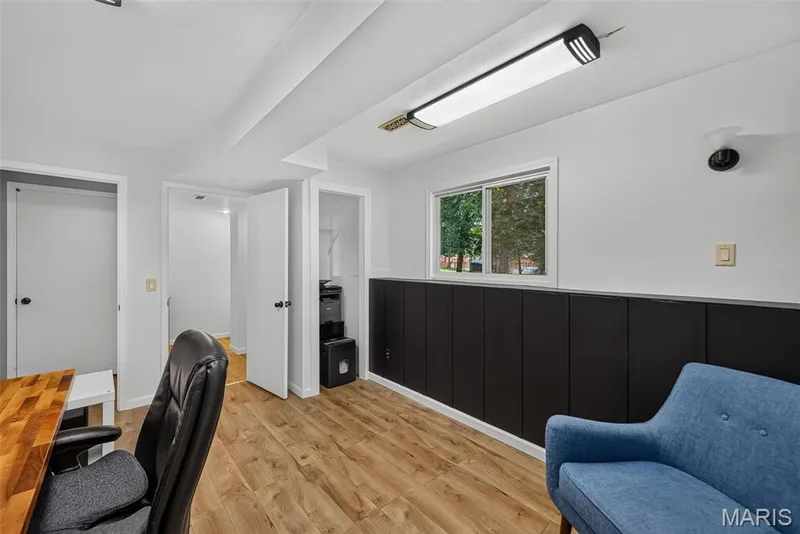 Modern office space featuring wood-finish flooring, recessed ceiling lighting, and a black paneled accent wall — 23 Crescent Woods Drive, St Peters, MO 63376