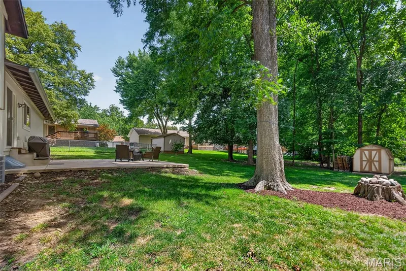Expansive backyard oasis featuring mature shade trees, lush manicured lawn — 23 Crescent Woods Drive, St Peters, MO 63376
